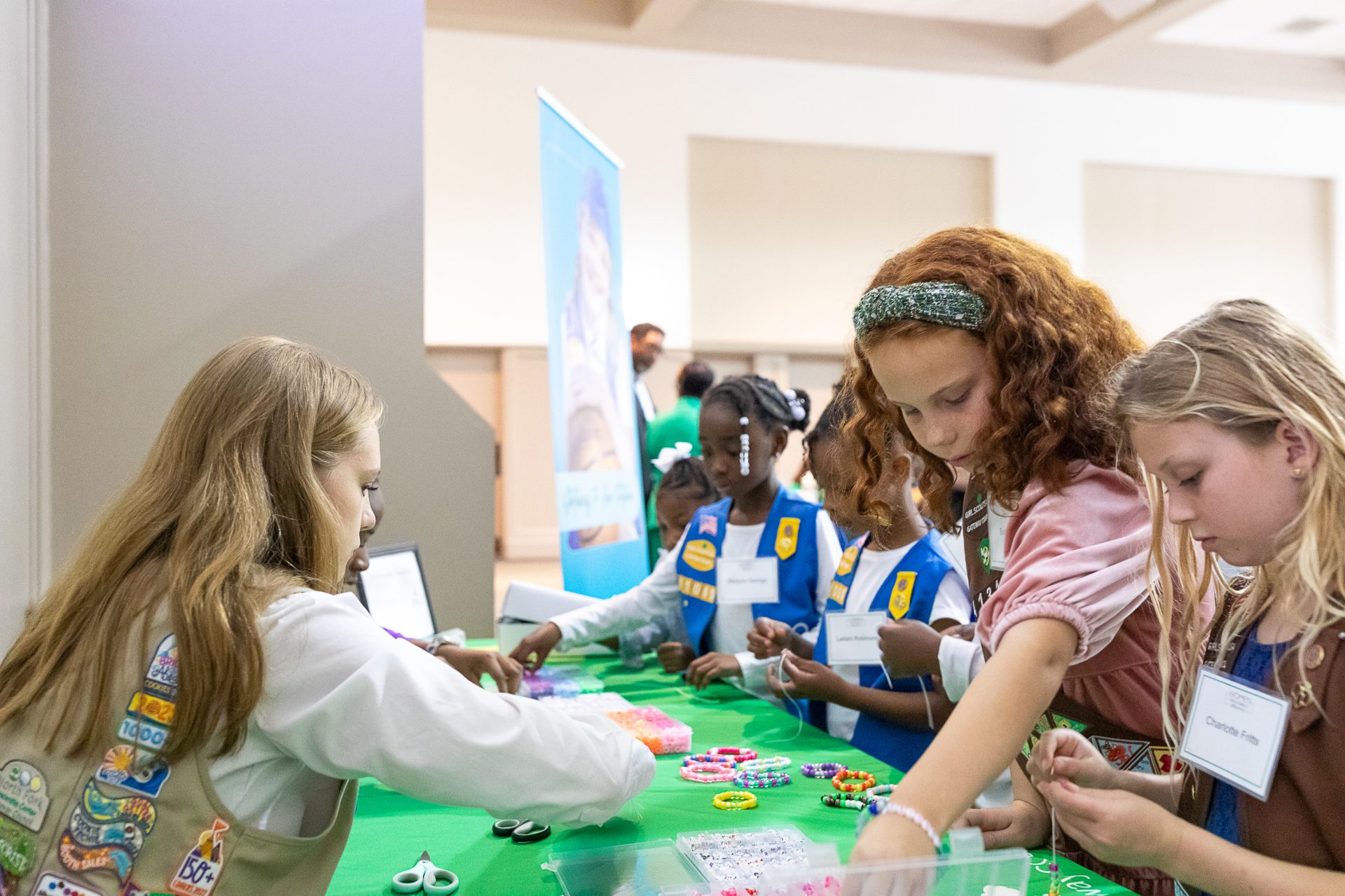 group of young girl scout daisies hiking with adult volunteer