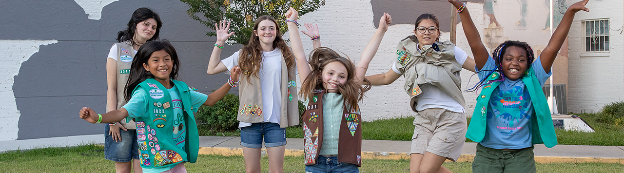  group of young girl scouts outside cheering 