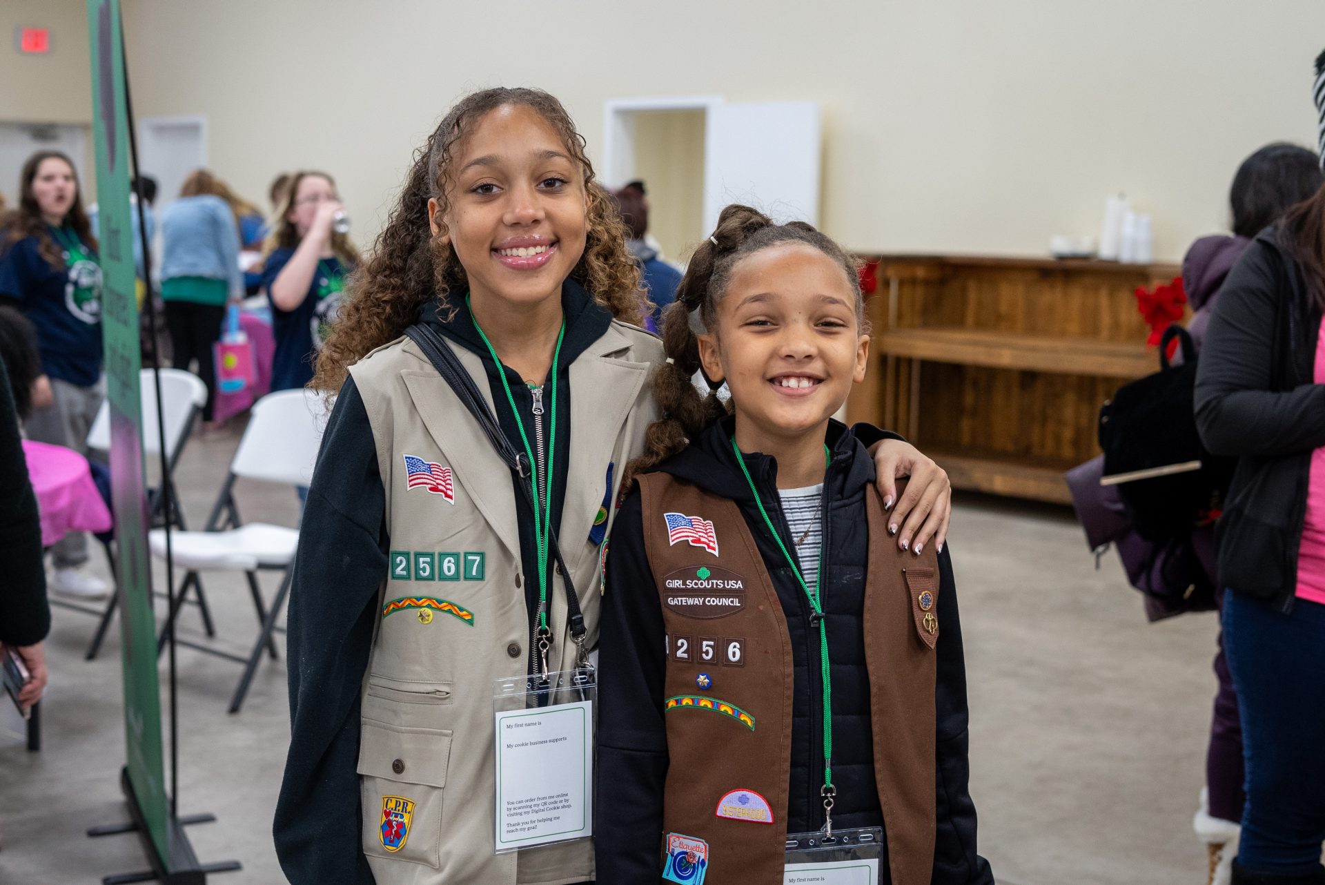 two sisters that are Girl Scouts smiling for picture