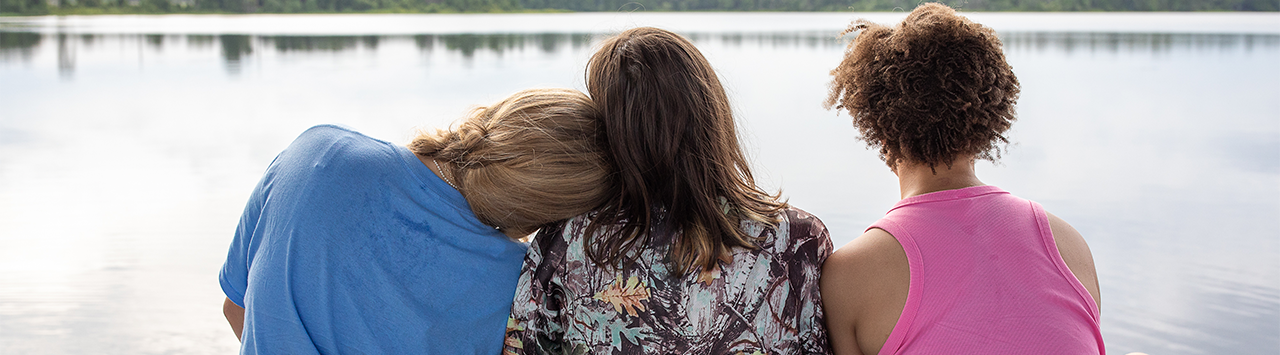  two girls kayaking across a lake 